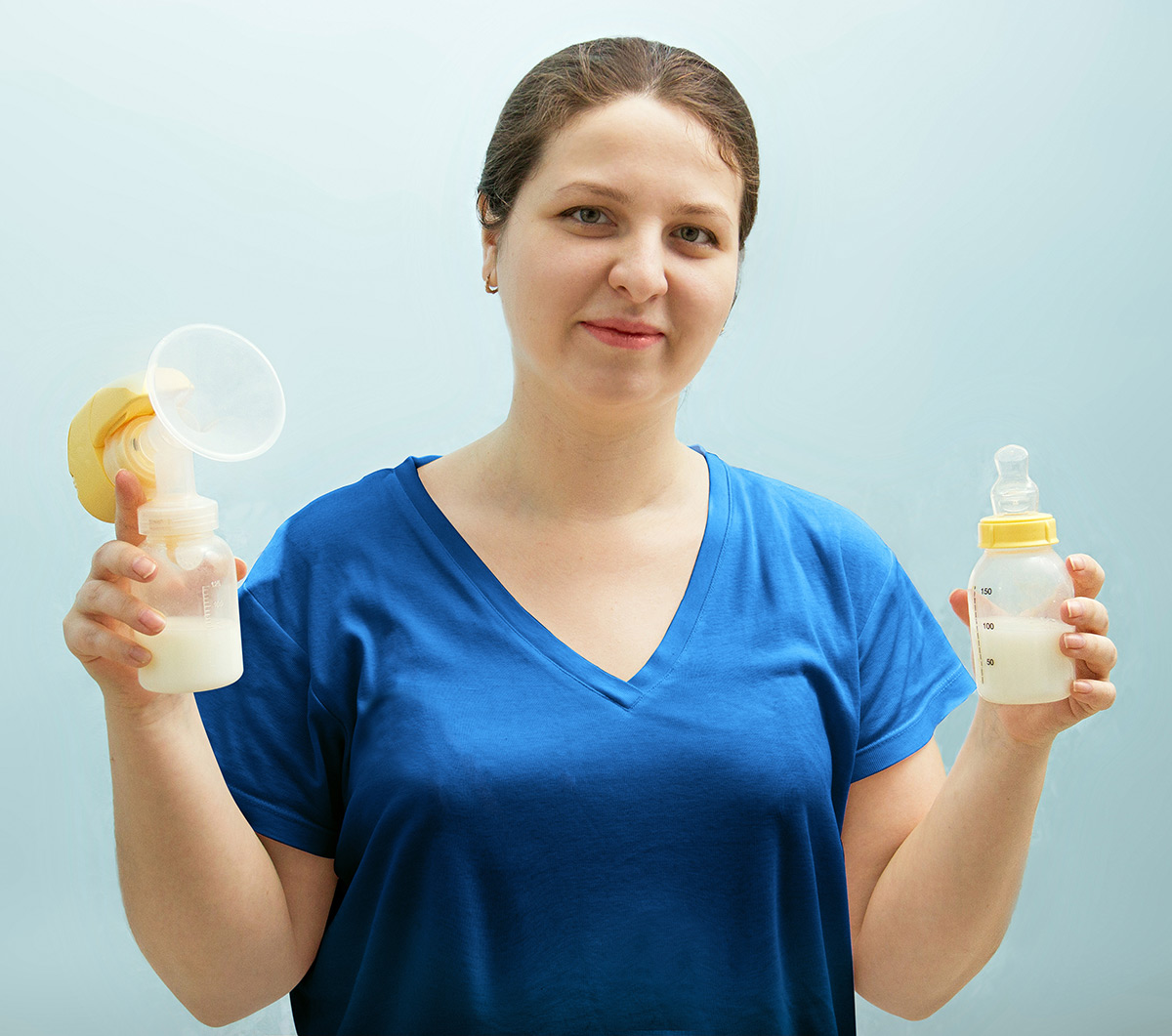 lactation consultant holding a breast pump and milk bottle